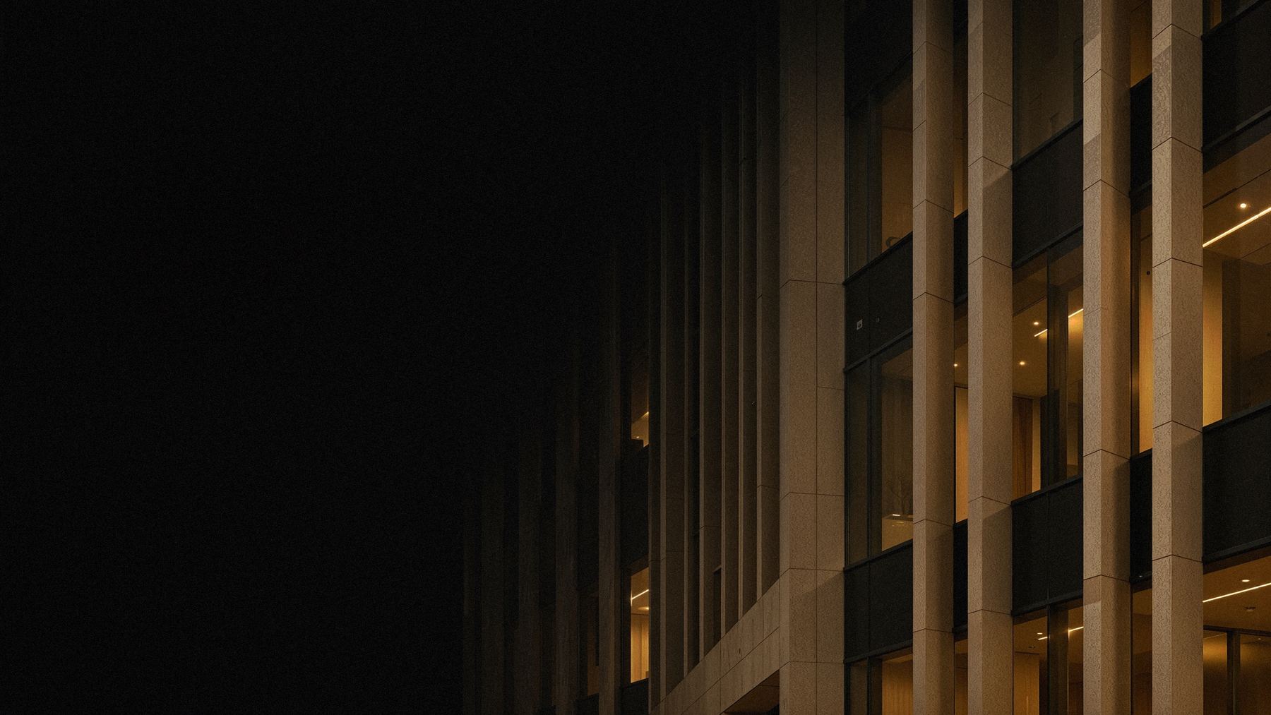 Illuminated stone and glass façade at night